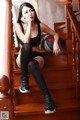 A woman sitting on the stairs with a basketball.