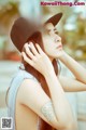 A woman wearing a black hat and headphones.