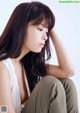 A woman sitting on the ground with her head in her hands.