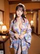 A woman in a blue kimono posing for the camera.